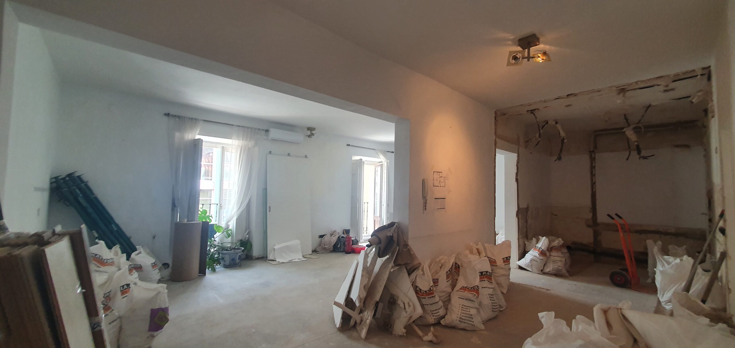 Reforma interior con paredes en blanco y obra pendiente.