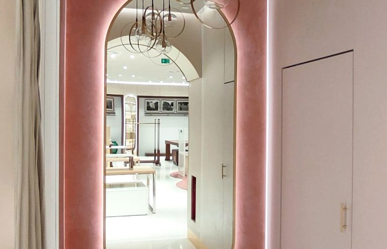 Interior moderno de tienda con espejo ovalado y lámparas.