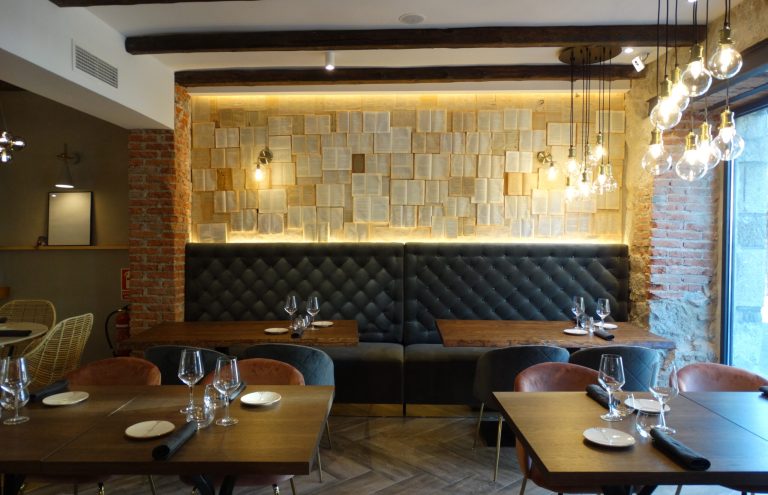 Interior restaurante con decoración rústica y mesas preparadas.