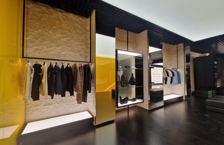 Interior de tienda de ropa moderna con ropa colgada.