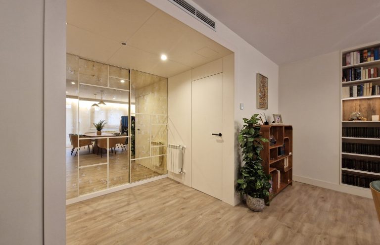 Interior moderno con espejo, librería y puerta blanca.