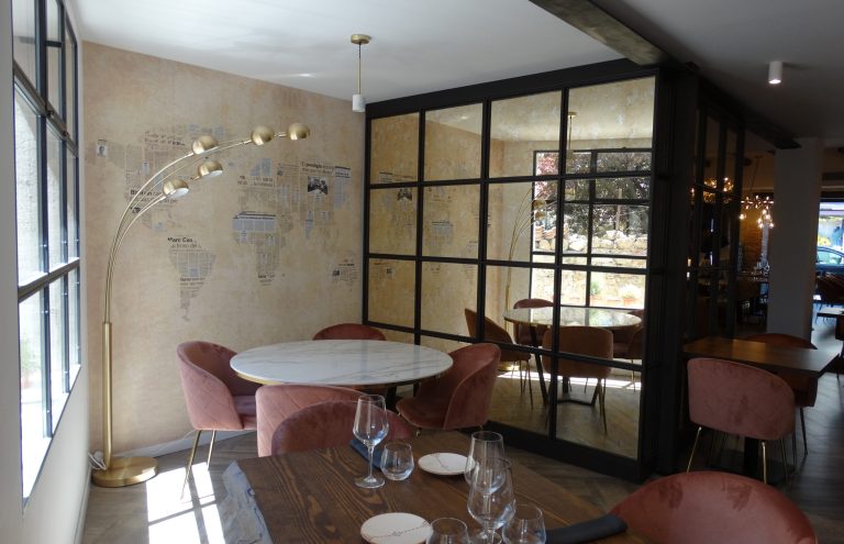 Mesa redonda y sillas rosas en restaurante elegante.