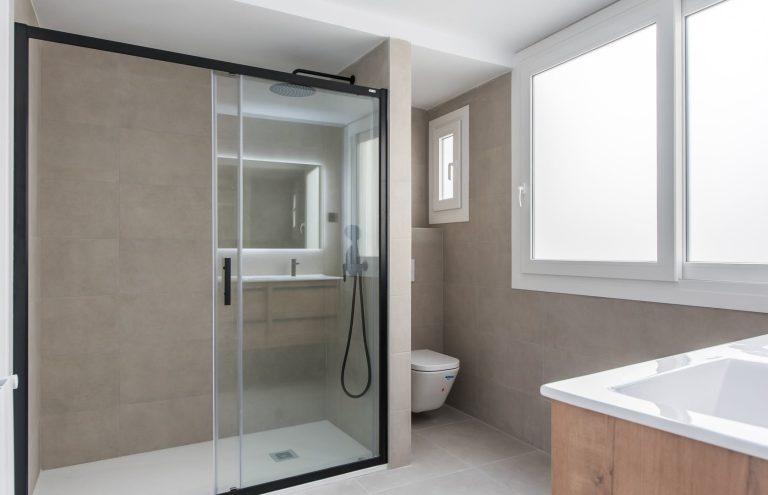 Baño moderno con ducha a ras de suelo y WC.