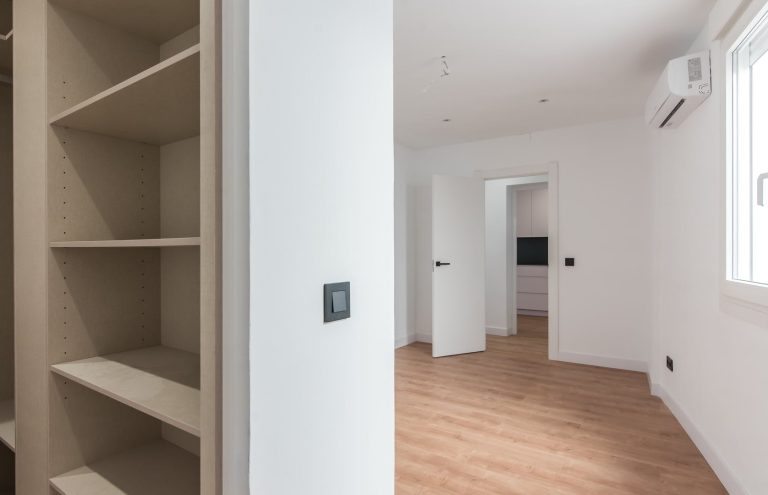 Dormitorio vacío con armario empotrado y suelo de madera.