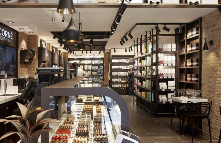 Interior de tienda de chocolate belga con mostrador y estanterías.