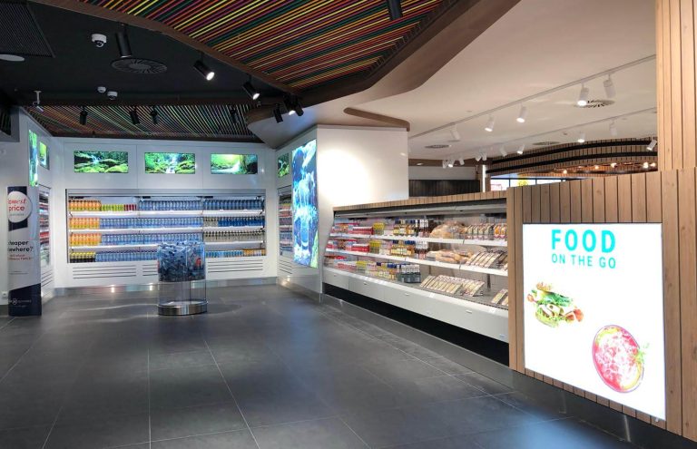 Tienda de conveniencia con bebidas, sándwiches y comida rápida.